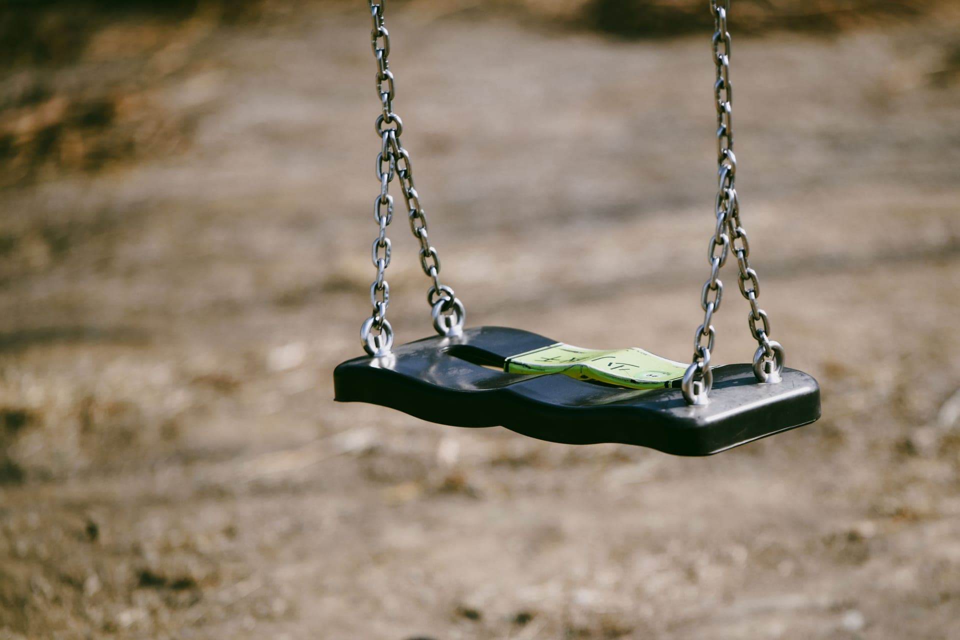 Close-up of an empty swing seat and its chains